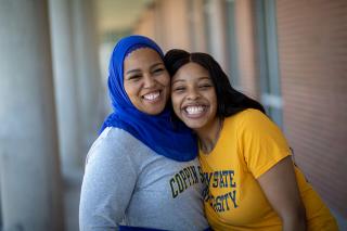 Two female students outside of a building on Coppin's campus