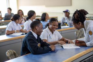 a professor helps students during in-class instruction