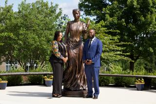 a man and woman pose with statue of Fanny Jackson Coppin