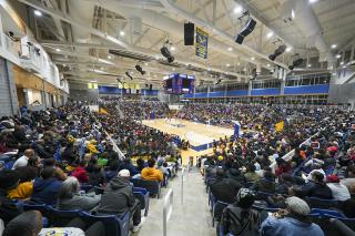 A view from the stands of the arena during a packed basketball game.